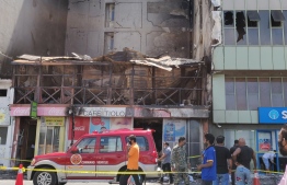 The blaze in Malé City on Friday night destroyed the two-storey Café Tiolo building and spread to the adjacent Gadhage Mohamed Fulhu Building where State Bank of India (SBI) and Ooredoo Maldives’ headquarters are located. PHOTO: MIHAARU