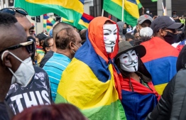 Demonstrators wear Guy Fawkes masks during a protest against the government's response to the oil spill disaster that happened in early August in front of Prime Minister's Office in Port Louis, on the island of Mauritius, on August 29, 2020. - The major oil spill caused by a Japanese ship that ran aground in Mauritius may pose a long-term threat to the region's ecology, including to the Indian Ocean island's delicate mangroves, Japanese experts said.  The bulk carrier MV Wakashio crashed into a reef last month spewing more than 1,000 tonnes of oil into pristine waters that are home to mangrove forests and endangered species. (Photo by Fabien Dubessay / AFP)