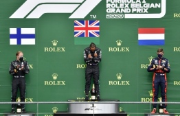 Winner Mercedes' British driver Lewis Hamilton (C) gestures on the podium next to second placed Mercedes' Finnish driver Valtteri Bottas (L) and third placed Red Bull's Dutch driver Max Verstappen after the Belgian Formula One Grand Prix at the Spa-Francorchamps circuit in Spa on August 30, 2020. (Photo by JOHN THYS / POOL / AFP)