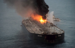 This handout photograph taken on September 4, 2020, and released by Sri Lanka's Air Force, shows an Indian coast guard ship (R) battling to extinguish the fire from the Panamanian-registered crude oil tanker New Diamond, some 60 km off Sri Lanka's eastern coast. - Indian warships on September 3 aided Sri Lanka's navy to extinguish a fire on a massive oil tanker off the island's eastern coast, officials said. (Photo by - / Sri Lankan Air Force / AFP) / 