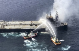 This handout photograph taken on September 4, 2020, and released by Sri Lanka's Air Force shows fireboats battling to extinguish a fire on the Panamanian-registered crude oil tanker New Diamond, some 60 kms off Sri Lanka's eastern coast where a fire was reported inside the engine room. - Panamanian-registered oil tanker burned out of control for a second day off Sri Lanka on September 4, raising fears of a major new oil spill in the Indian Ocean. Sri Lankan navy and India coastguard fired water cannon while an air force helicopter dropped water on the drifting New Diamond. (Photo by - / Sri Lankan Air Force / AFP) / 