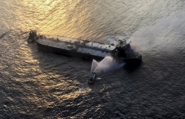 This handout photograph taken on September 4, 2020, and released by Sri Lanka's Air Force shows fireboats battling to extinguish a fire on the Panamanian-registered crude oil tanker New Diamond, some 60 kms off Sri Lanka's eastern coast where a fire was reported inside the engine room. - Panamanian-registered oil tanker burned out of control for a second day off Sri Lanka on September 4, raising fears of a major new oil spill in the Indian Ocean. Sri Lankan navy and India coastguard fired water cannon while an air force helicopter dropped water on the drifting New Diamond. (Photo by - / Sri Lankan Air Force / AFP) / 
