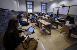 Students wearing face masks and keeping their social distance attend a class at the Comillas University on the first day of classes for the new academic year, in Madrid on September 7, 2020. - Spain will require all students aged six or older to wear masks and is urging them to wash their hands at least five times a day. The country was one of the hardest-hit countries when the coronavirus struck Europe this year before a strict lockdown helped reduce the outbreak's spread. But infections have surged since the lockdown measures were fully removed at the end of June. (Photo by OSCAR DEL POZO / AFP)