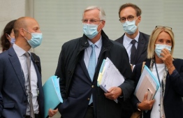 EU chief Brexit negotiator Michel Barnier (C), wearing a face mask as a precaution against the transmission of COVID-19, walks with members of his team towards a conference centre in London on September 9, 2020 for the latest round of trade talks with the UK. - British Prime Minister Boris Johnson was accused Wednesday of presiding over a "rogue state" as his government introduced legislation that intentionally breaches its EU withdrawal treaty in the messy countdown to a full Brexit divorce. (Photo by Isabel Infantes / AFP)
