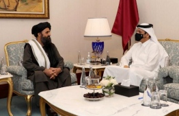 A handout picture released by the Qatar News Agency (QNA) on September 12, 2020 shows Qatar's Deputy Prime Minister and Foreign Minister Sheikh Mohammed bin Abdulrahman al-Thani(R) meeting with Taliban co-founder Mullah Abdul Ghani Baradar on the sidelines of the opening ceremony of the Afghan negotiations. - Peace talks between the Taliban and the Afghan government opened in Qatar, marking what US Secretary of State Mike Pompeo heralded as a "truly momentous" breakthrough in nearly two decades of relentless conflict. (Photo by - / Qatar News Agency / AFP) / 