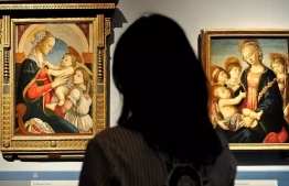 A visitor looks at two Botticelli paintings on display at the Palazzo Strozzi in Florence in 2011 ANDREAS SOLARO AFP/File