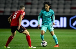 Liverpool's Japanese midfielder Takumi Minamino (R) controls the ball in front of Lincoln City's Scottish midfielder James Jones (L) during the English League Cup third round football match between Lincoln City and Liverpool at the LNER Stadium in Lincoln, north-east of England, on September 24, 2020. PETER POWELL / POOL / AFP