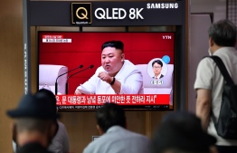 People watch a television news broadcast showing file footage of North Korean leader Kim Jong Un, at a railway station in Seoul on September 25, 2020. - North Korean leader Kim Jong Un apologised on September 25 over the killing of a South Korean at sea, calling it an "unexpected and disgraceful event", Seoul's presidential office said. (Photo by Jung Yeon-je / AFP)