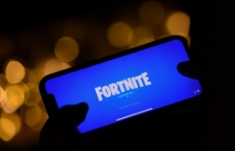 (FILES) In this file photo taken on August 14, 2020 This illustration picture shows a person logging into Epic Games' Fortnite on their smartphone in Los Angeles. - Epic Games will strive anew September 28 to convince a judge that its hit title Fortnite should be restored to Apple's App Store, despite sidestepping the tech titan's standard commission on transactions. (Photo by Chris DELMAS / AFP)