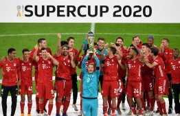 Bayern Munich's German goalkeeper Manuel Neuer and teammates celebrate with the trophy after winning the German Supercup football match FC Bayern Munich v BVB Borussia Dortmund in Munich, Southern Germany, on September 30, 2020. (Photo by ANDREAS GEBERT / POOL / AFP) / DFL REGULATIONS PROHIBIT ANY USE OF PHOTOGRAPHS AS IMAGE SEQUENCES AND/OR QUASI-VIDEO