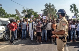 People shout slogans facing the police as they protest against the alleged gang-rape and murder of a 19-year-old woman in Bool Garhi of Hathras district in Uttar Pradesh state on October 3, 2020. - Five senior police officers have been suspended over their handling of an investigation into the gang-rape and murder of a 19-year-old woman that has sparked outrage across India and triggered days of protests. (Photo by Pawan SHARMA / AFP)