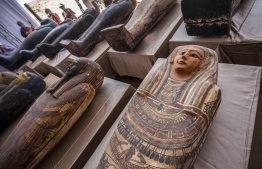 A picture taken on October 3, 2020 shows sarcophaguses, excavated by the Egyptian archaeological mission which discovered a deep burial well with more than 59 human coffins closed for more than 2,500 years, displayed during a press conference  at the Saqqara necropolis, 30 kms south of the Egyptian capital Cairo. - They were unearthed south of Cairo in the sprawling burial ground of Saqqara, the necropolis of the ancient Egyptian capital of Memphis, a UNESCO World Heritage site. Their exteriors are covered in intricate designs in vibrant colours as well as hieroglyphic pictorials. (Photo by Khaled DESOUKI / AFP)