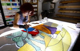 Lebanese stained glass artist Maya Husseini, 60, works on a piece for a cathedral under construction in Jordan, her main project before the Beirut port blast, in her basement workshop on the outskirts of the capital Beirut, on September 18, 2020. - Husseini had hoped to retire after decades of designing colourful windows, but now she is overwhelmed with requests after a massive explosion ripped through Beirut on August 4. 
She is one of several artists slowly starting to restore the artworks devastated in disaster. (Photo by ANWAR AMRO / AFP)