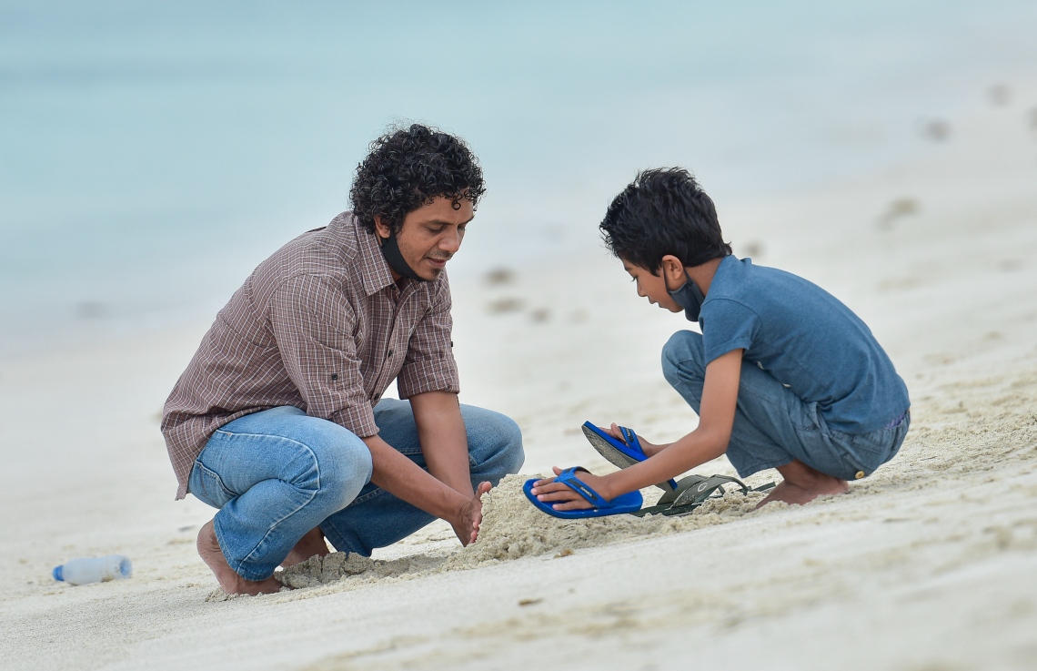 ހުޅުމާލެ: އޮކްޓޫބަރު 2، 2020- ހުޅުމާލޭގެ ދެވަނަ ފިޔަވަހި ބަލައިލަން މިއަދު ހަވީރު ދިޔަ ކުޑަކުއްޖަކު، އޭނާގެ އާއިލާގެ މީހަކާ އެކު ވެއްޔާ ކުޅެނީ: ދެވަނަ ފިޔަވަހީގެ ގިނަ މަގުތައް އަދި ވަނީ ބަންދުކޮށްފައި.---ފޮޓޯ: އަހުމަދު އަވްޝަން/މިހާރު