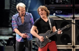(FILES) In this file photo taken on February 07, 2012 Singer David Lee Roth (L) and musician Eddie Van Halen of Van Halen perform at their dress rehearsal for family and friends at the Forum in Inglewood, California. - Eddie Van Halen, of the iconic hard rock group that bore his family name, died on October 6, 2020 following a long battle with cancer, his son announced. (Photo by KEVIN WINTER / GETTY IMAGES NORTH AMERICA / AFP)