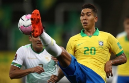 Brazil's Roberto Firmino (R) and Bolivia's Gabriel Valverde vie for the ball during their 2022 FIFA World Cup South American qualifier football match at the Neo Quimica Arena, also known as Itaquerao, in Sao Paulo, Brazil, on October 9, 2020, amid the COVID-19 novel coronavirus pandemic. (Photo by Buda Mendes / POOL / AFP)