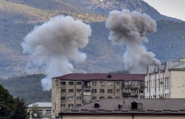 Smoke rises after shelling in Stepanakert on October 9, 2020, during ongoing fighting between Armenia and Azerbaijan over the disputed region of Nagorno-Karabakh. - Armenia and Azerbaijan were due to hold their first high-level talks on Friday after nearly two weeks of clashes over the disputed Nagorno-Karabakh region, with hopes rising that a ceasefire could be brokered in Moscow. (Photo by ARIS MESSINIS / AFP)