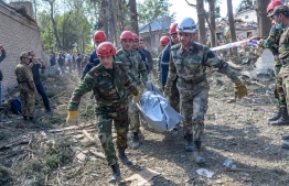 Rescuers carry away the body of a victim at the blast site hit by a rocket during the fighting between Armenia and Azerbaijan over the breakaway region of Nagorno-Karabakh, in the city of Ganja, Azerbaijan, on October 11, 2020. (Photo by Bulent Kilic / AFP)