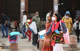 Shoppers wearing facemasks as a preventive measure against the Covid-19 coronavirus walk through a market area in the old quarters of New Delhi on October 11, 2020. India's coronavirus cases surged past seven million on October 11, taking it ever closer to overtaking the United States as the world's most infected country. PHOTO: SAJJAD HUSSAIN / AFP