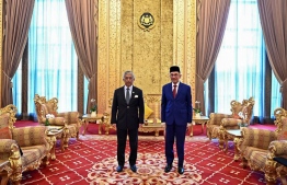 This handout picture taken and released by the National Palace on October 13, 2020 shows Malaysian politician Anwar Ibrahim (R) and Malaysia's King, Sultan Abdullah Sultan Ahmad Shah (L) pose for pictures before their meeting at National Palace in Kuala Lumpur. - Malaysian opposition leader Anwar Ibrahim had a long-awaited meeting with the king October 13, seeking to prove he has support to take power and fulfil a decades-old ambition of becoming premier. (Photo by Handout / Malaysia National Palace / AFP) / -----EDITORS NOTE --- RESTRICTED TO EDITORIAL USE - MANDATORY CREDIT "AFP PHOTO / MALAYSIA NATIONAL PALACE" - NO MARKETING - NO ADVERTISING CAMPAIGNS - DISTRIBUTED AS A SERVICE TO CLIENTS