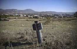 An unexploded BM-30 Smerch missile is seen on the outskirts of Stepanakert on October 12, 2020, during the ongoing military conflict between Armenia and Azerbaijan over the breakaway region of Nagorno-Karabakh. (Photo by ARIS MESSINIS / AFP)
