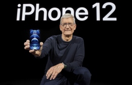 In this photo released by Apple, Apple CEO Tim Cook holds up the all-new iPhone 12 Pro during an Apple event at Apple Park in Cupertino, California on October 13, 2020. (Photo by Brooks KRAFT / Apple Inc. / AFP) / 