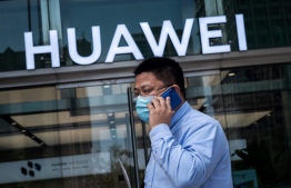 (FILES) In this file photo taken on May 25, 2020 a man walks past a shop for Chinese telecoms giant Huawei in Beijing. Huawei’s revenue growth slowed significantly in the first nine months of 2020, the Chinese telecom giant said on October 23, 2020, citing "intense pressure" on operations during the coronavirus and as the US moves to cut off 
NICOLAS ASFOURI / AFP