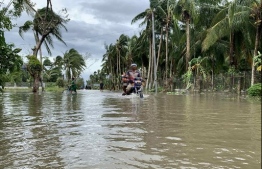 A motorcyclist traverses a flooded street after Typhoon Molave hit the town of Pola, Oriental Mindoro province, on October 26, 2020. Typhoon Vamco, which hit Manila on November 12, is the third such storm to hit the country,  just a couple of weeks apart. (Photo by Erik DE CASTRO / AFP)