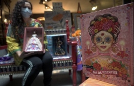 Mexican doll collector Zoila Muntane poses with a ìCatrinaî Barbie doll at the Museum of the Old Mexican Toy in Mexico City on October 20, 2020. - For second year in a row, US toy company Mattel launched a ìDay of the Deadî edition of the Barbie doll. (Photo by ALFREDO ESTRELLA / AFP)