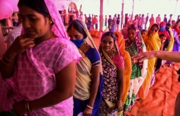 Voters queue up to cast their ballots for Bihar state assembly elections at a polling station in Masaurhi on October 28, 2020. (Photo by Prakash SINGH / AFP)