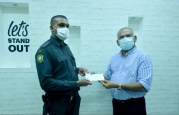 ރޫޓުގެ އެމްޑީ އަބްދުﷲ ރާފިއު، ބީއޯސީގެ ސެކިއުރިޓީ ބަލަހައްޓަން ހުިރ މުހައްމަދު ހަސަން މަނިކަށް 50،000 ރުފިޔާގެ ޗެކެއް ހަވާލުކުރައްވަނީ -- ފޮޓޯ: ނިޝާން އަލީ/ މިހާރު