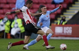 Sheffield United's English defender Chris Basham (L) vies with 17during the English Premier League football match between Sheffield United and Manchester City at Bramall Lane in Sheffield, northern England on October 31, Manchester City's English midfielder Phil Foden 20. (Photo by Tim Keeton / POOL / AFP) / RESTRICTED TO EDITORIAL USE. No use with unauthorized audio, video, data, fixture lists, club/league logos or 'live' services. Online in-match use limited to 120 images. An additional 40 images may be used in extra time. No video emulation. Social media in-match use limited to 120 images. An additional 40 images may be used in extra time. No use in betting publications, games or single club/league/player publications. / 