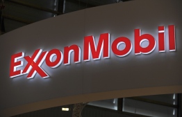 (FILES) In this file photo taken on June 02, 2015, the logo of US oil and gas giant ExxonMobil during the World Gas Conference exhibition in Paris. - Exxon Mobil reported another large quarterly loss on October 30, 2020, on a plunge in oil prices due to economic weakness that has prompted petroleum giants to slash capital spending. The US oil giant lost $680 million in the third quarter, compared with profits of $3.2 billion in the year-ago period. (Photo by ERIC PIERMONT / AFP)