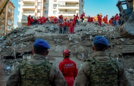 Volunteers and rescue personnel search for survivors in a collapsed building in Izmir, on November 1, 2020, after a powerful earthquake struck Turkey's western coast and parts of Greece. - Rescue workers were searching eight buildings in Izmir on November 1, despite dwindling hope for survivors, as the death toll of a powerful magnitude earthquake which hit western Turkey rose to 49. The 7.0-magnitude quake has also injured 896 in Turkey, the Turkish emergency authority AFAD said, after striking on October 30 afternoon near the west coast town of Seferihisar in Izmir province. (Photo by Yasin AKGUL / AFP)