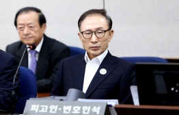 (FILES) In this file photo taken on May 23, 2018 former South Korean president Lee Myung-Bak (R) attends his trial at the Seoul Central District Court in Seoul. - Lee was ordered back to prison on October 29, 2020 as the country's Supreme Court upheld a 17-year jail term for bribery and embezzlement offences. (Photo by Chung Sung-Jun / POOL / AFP)