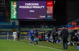 Referee Andre Marriner checks the VAR screen before awarding a penalty for a challenge on Leicester City's English midfielder James Maddison (unseen) by Leeds United's Polish midfielder Mateusz Klich (unseen) during the English Premier League football match between Leeds United and Leicester City at Elland Road in Leeds, northern England on November 2, 2020. (Photo by Jon Super / POOL / AFP) / RESTRICTED TO EDITORIAL USE. No use with unauthorized audio, video, data, fixture lists, club/league logos or 'live' services. Online in-match use limited to 120 images. An additional 40 images may be used in extra time. No video emulation. Social media in-match use limited to 120 images. An additional 40 images may be used in extra time. No use in betting publications, games or single club/league/player publications. / 