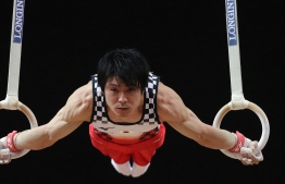 (FILES) In this file photo taken on October 29, 2018 Kohei Uchimura of Japan competes in the men's rings during the Men's Team Final of the 2018 FIG Artistic Gymnastics Championships at Aspire Dome in Doha. - The three-time Olympic gold medallist tested positive for Covid-19 but several subsequent follow-up tests were negative, and has been cleared to take part in an international gymnastics competition on November 8, 2020, described as a "litmus test" of its ability to hold sports events during the pandemic, less than a year before the virus-delayed Olympics. (Photo by KARIM JAAFAR / AFP)