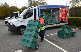 A shop worker moves trays used in the click and collect service at a Tesco supermarket in Pembury, south-east of London on November 6, 2020, as the second lockdown comes into force in England. - A united effort to tackle spiking coronavirus infection rates has been called for as 56 million people in England went into a second lockdown but with the public weary of restrictions and fearing for their livelihoods. (Photo by Ben STANSALL / AFP)