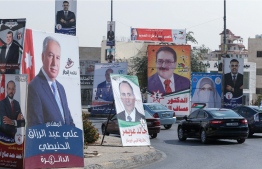 Cars advance on a road lined with campaign banners and slogans of candidates for the upcoming Jordanian parliamentary elections in the capital Amman, on November 3, 2020. - Voters in coronavirus-battered Jordan go to the polls on November 10, in an election focused on the Arab country's economic crisis which has been heightened by the devastating pandemic. (Photo by Khalil MAZRAAWI / AFP)