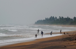 Sri Lankan children play along a beach in Panadura, some 25 km ssouth of the capital Colombo on November 4, 2020. (Photo by LAKRUWAN WANNIARACHCHI / AFP)