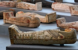 A picture shows wooden sarcophagi on display during the unveiling of an ancient treasure trove of more than a 100 intact sarcophagi, at the Saqqara necropolis 30 kms south of the Egyptian capital Cairo, on November 14, 2020. - Egypt announced the discovery of an ancient treasure trove of more than a 100 intact sarcophagi, the largest such find this year. The sealed wooden coffins, unveiled on site amid fanfare, belonged to top officials of the Late Period and the Ptolemaic period of ancient Egypt. They were found in three burial shafts at depths of 12 metres (40 feet) in the sweeping Saqqara necropolis south of Cairo. (Photo by Ahmed HASAN / AFP)
