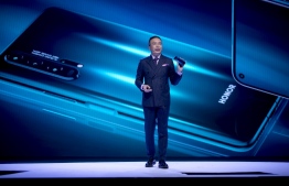 (FILES) This file photo taken on May 21, 2019 shows George Zhao, the president of Honor, a sub-brand of Chinese telecommunications company Huawei, speaking during a keynote speech at an event to launch the Honor 20 Series smartphones at Battersea Evolution in London. - Chinese telecom giant Huawei announced November 17, 2020 it has sold its Honor budget phone line to a domestic consortium, a move it said was necessary to keep the brand alive amid "tremendous" supply chain pressures caused by US sanctions. (Photo by Tolga Akmen / AFP)