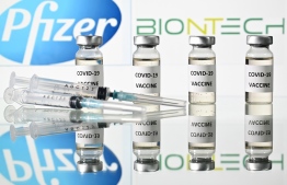An illustration picture shows vials with Covid-19 Vaccine stickers attached and syringes with the logo of US pharmaceutical company Pfizer and German partner BioNTech, on November 17, 2020. (Photo by JUSTIN TALLIS / AFP)