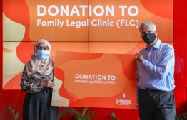 Family Legal Clinic (FLC)'s Chairperson Shafeea Riza (L) receiving a donation of MVR 50,000 by the Bank of Maldives, represented by its CEO and Managing Director Tim Sawyer. PHOTO: BANK OF MALDIVES