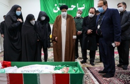 Iran's Judiciary Chief Ayatollah Ebrahim Raisi (C) pays respects to the body of slain scientist Mohsen Fakhrizadeh among his family, in the capital Tehran on November 28, 2020. - Mohsen Fakhrizadeh, dubbed by Israel as the "father" of Iran's nuclear programme, died on November 27 after being seriously wounded when assailants targeted his car and engaged in a gunfight with his bodyguards outside Tehran, according to Iran's defence ministry. The assassination comes less than two months before US President-elect Joe Biden is due to take office, after a tumultuous four years of hawkish foreign policy in the Middle East under President Donald Trump. (Photo by - / MIZAN NEWS AGENCY / AFP)