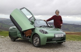 Hugo Spowers, chief engineer and founder of Riversimple, poses for a photograph with one of his company's hydrogen powered 'Rasa' cars in Llandgynidr, near Brecon in Wales on November 23, 2020. - Hydrogen-powered car manufacturer Riversimple is hoping to steal a march on competitors ahead of Britain's promised "green revolution", which would see petrol-powered cars banned within 10 years. Riversimple is only an ambitious upstart compared to the Asian automotive giants, but is currently the only British manufacturer in the sector with its flagship model, the Rasa. Founder Hugo Spowers is keen to take on the big boys with his self-designed model, whose name derives from the Latin 'tabula rasa', or clean slate. Advanced testing of the Rasa will begin over the next few months, with paying customers including Monmouthshire District Council in south Wales, which has given the go-ahead for a hydrogen refuelling station in the town of Abergavenny. (Photo by GEOFF CADDICK / AFP)