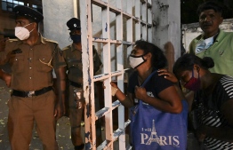 A relatives of an inmate weeps at Ragama hospital on the outskirts of Colombo on November 30, 2020 a day after a prison riot over the surge of coronavirus infections. - Sri Lankan prison guards shot dead eight inmates and wounded at least 71 others in a riot sparked by anger over rising coronavirus infections, officials said on November 30. (Photo by LAKRUWAN WANNIARACHCHI / AFP)