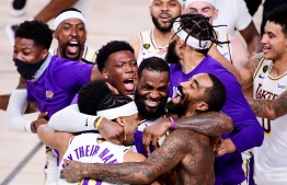 (FILES) In this file photo taken on October 11, 2020, LeBron James (C) of the Los Angeles Lakers celebrates with teammates after winning the 2020 NBA Championship in Game Six at AdventHealth Arena in Lake Buena Vista, Florida. NOTE TO USER: User expressly acknowledges and agrees that, by downloading and or using this photograph, User is consenting to the terms and conditions of the Getty Images License Agreement.   Douglas P. DeFelice/Getty Images/AFP - The NBA season will tip off Christmas week with two games on opening night, highlighted by the Los Angeles Lakers championship ring ceremony, the league announced on December 2, 2020. (Photo by Douglas P. DeFelice / GETTY IMAGES NORTH AMERICA / AFP)