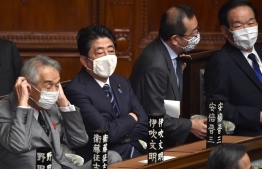 This picture taken on October 26, 2020 shows Japan's former prime minister Shinzo Abe (2nd L) attending a plenary session of the lower house of parliament in Tokyo. - Japanese prosecutors are seeking to question former prime minister Shinzo Abe over a scandal involving the cost of events held for his supporters, local media said on December 3, 2020. (Photo by Kazuhiro NOGI / AFP)