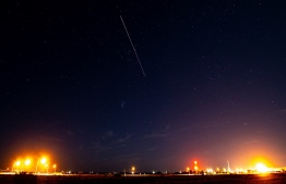 A long exposure shows the light trail of a re-entry capsule, carrying samples collected from a distant asteroid after being released by Japanese space probe Hayabusa-2, entering the Earth's atmosphere as seen from Coober Pedy in South Australia early on December 6, 2020. (Photo by Morgan Sette / AFP)